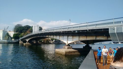 Bridge over river against sky in city