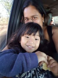 Portrait of mother and daughter sitting in car