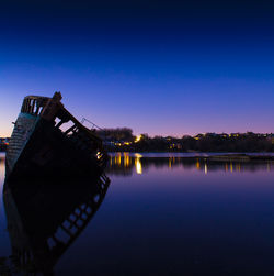 Scenic view of lake against clear sky at night