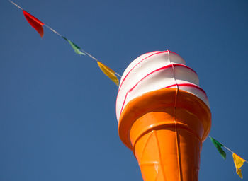 Low angle view of flag against clear blue sky