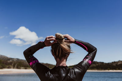 Rear view of woman wearing wetsuit at beach