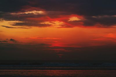 Scenic view of sea against dramatic sky during sunset