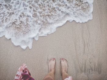 Low section of woman standing on beach