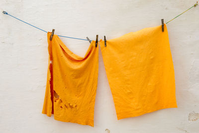 Close-up of clothes drying on clothesline against white wall