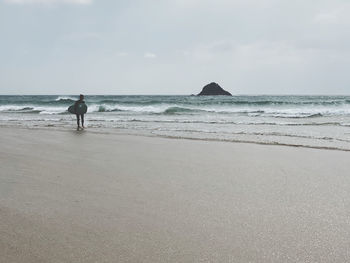 People walking at beach against sky surfing surfer surf big waves tube ocean atlantic sea water 