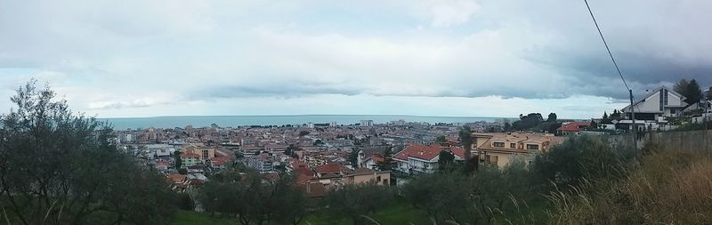 View of cityscape against cloudy sky