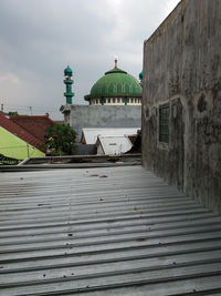 Footpath amidst buildings against sky