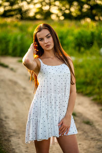 Young woman standing against trees