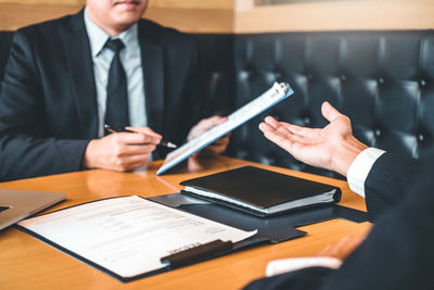 Midsection of man holding camera on table