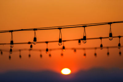 Close-up of silhouette metallic structure against sky during sunset