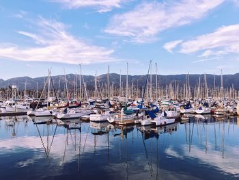 Sailboats moored in calm sea against sky