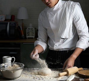 Midsection of man preparing food in kitchen