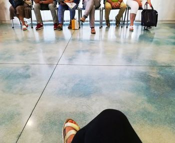 Low section of people standing on tiled floor