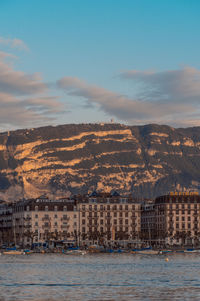 Scenic view of sea and buildings against sky during sunset