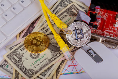 High angle view of cables with bitcoins and banknotes