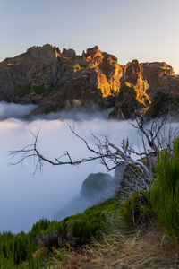 Scenic view of land and mountains against sky