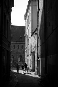 People walking on street amidst buildings in city