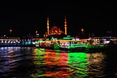 Illuminated boats in river at night