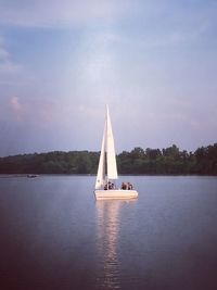 Sailboat sailing on lake against sky