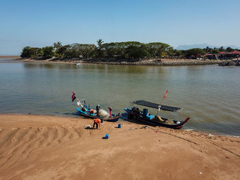 People on beach against clear sky