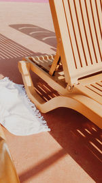 High angle view of lounge chair by towel at beach