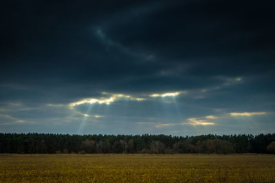 Scenic view of field against cloudy sky