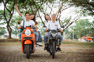 Side view of man riding motor scooter on road
