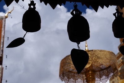 Low angle view of lighting equipment hanging against sky