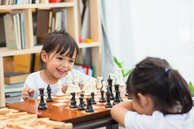 Portrait of cute girl playing with baby