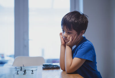 Portrait of boy sitting on table