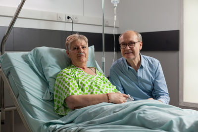 Man and woman sitting on bed at home