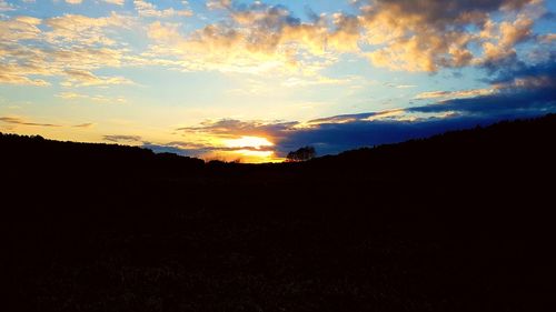 Silhouette landscape against sky during sunset