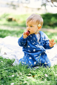 Cute boy sitting on field