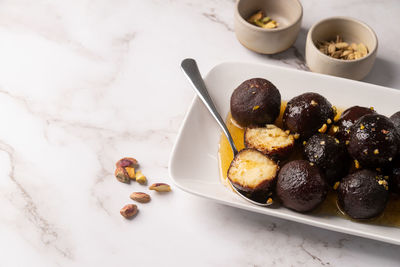 Traditional indian sweets. sweet gulab jamun on whiet plate on marble background