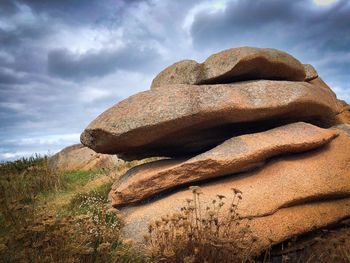 Low angle view of rocks on rock against sky