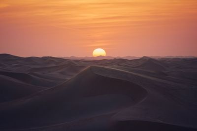 Scenic view of desert against sky during sunset