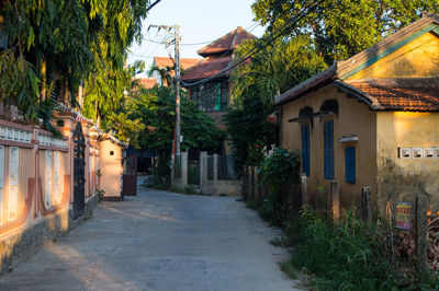 Houses by trees in city against sky