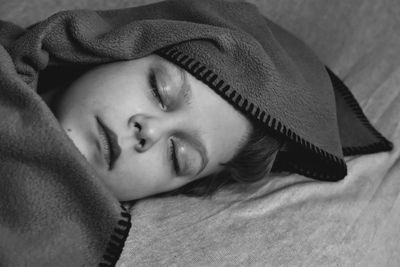 Close-up of baby sleeping on bed at home