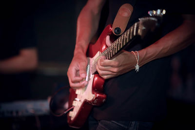 Midsection of man playing guitar