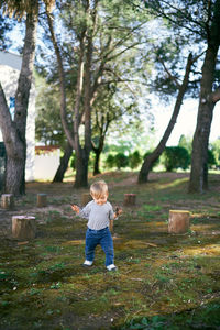 Full length of boy on field against trees