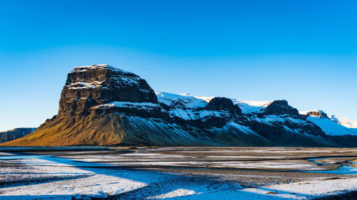 Scenic view of snowcapped mountains against clear blue sky