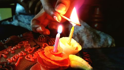 Close-up of hand holding burning candle