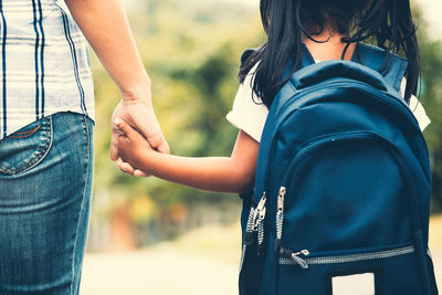 Midsection of couple holding hands