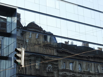 Low angle view of glass building against sky