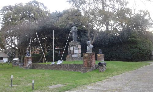 View of cross on field against trees