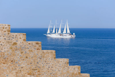 Sailboat sailing on sea against clear sky