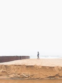 Man on beach against clear sky