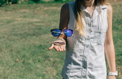 Midsection of woman levitating sunglasses