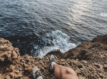 Low section of man on rock at beach