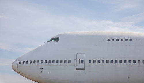 Airplane on airport runway against sky